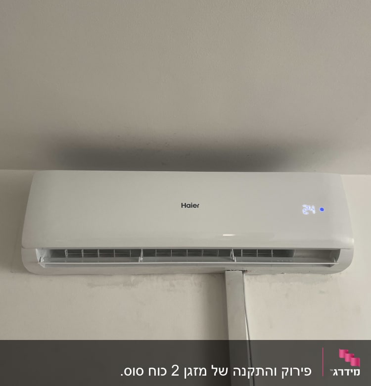 מזגן קיר לבן מותקן על קיר עם צינור חיבור